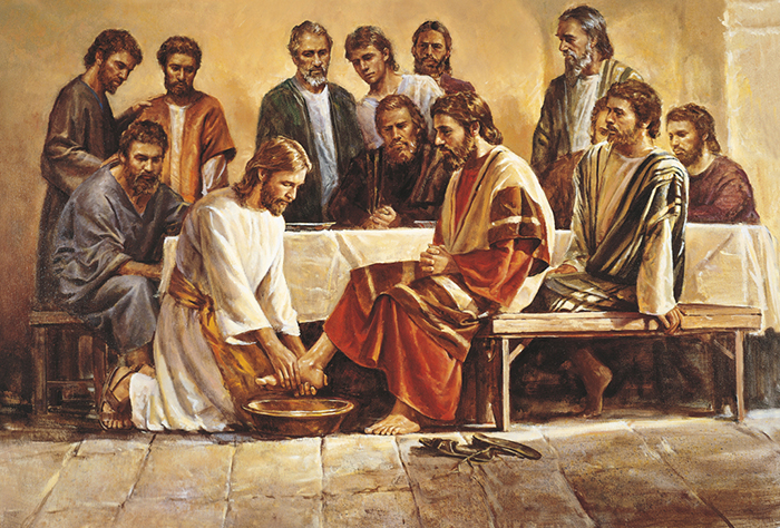 Иисус Христос умывает ноги своим ученикам.