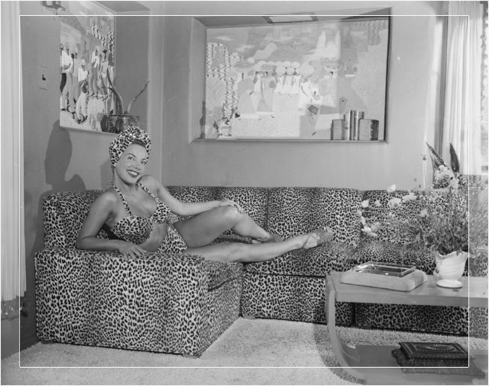 Кармен Миранда в экзотическом бикини с леопардовым принтом, подходящее к её дивану, в своём голливудском доме. 