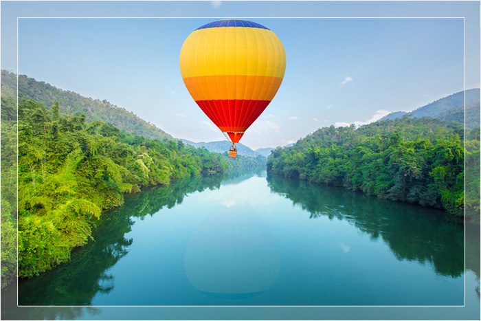 Воздушный шар пролетает над рекой.