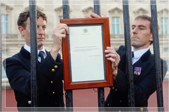 Члены королевского двора размещают на воротах Букингемского дворца объявление о смерти королевы Елизаветы II в Балморале, 8 сентября 2022 года.