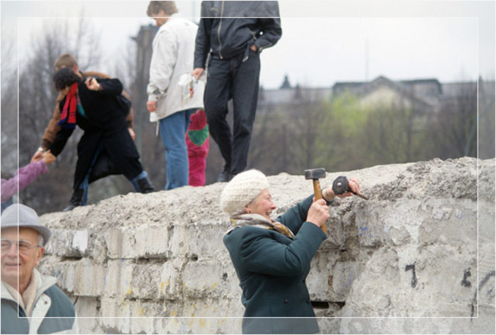 Немка пытается разрушать Берлинскую стену с помощью молотка. Берлин, 1989 год.