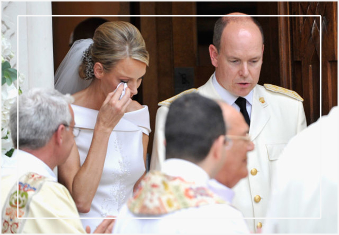 Принцесса Шарлин вытирает слёзы, когда они с князем Альбером II покидают церковь Sainte Devote после религиозной свадебной церемонии 2 июля 2011 года в Монако.