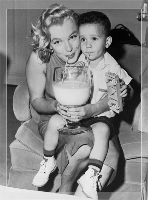 Мэрилин Монро пьёт молоко с молодым Уильямом Метцлером, бенефициаром Молочного фонда.