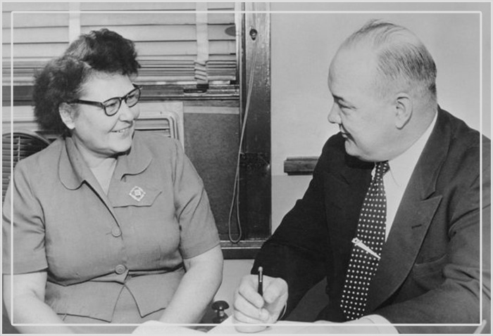 Нэнни Досс смеётся во время своего допроса капитаном Гарри Стеге в полицейском участке после того, как она призналась в отравлении четырёх из пяти своих мужей, 29 ноября 1954 года.