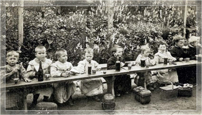 Младшие школьники с собственной корзинкой для обеда и бутылочкой вина около 1900 года.