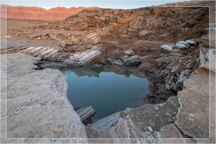 Падение уровня воды приводит к появлению подобных воронок, раскрывающих многослойную геологию Мёртвого моря.