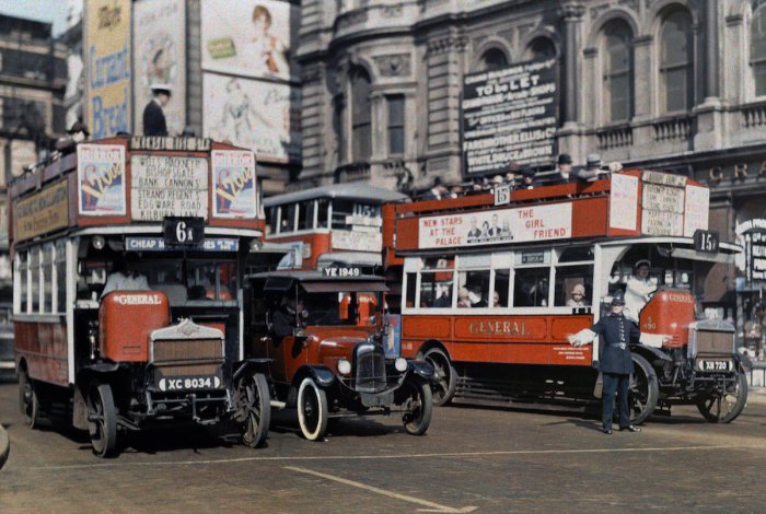 Регулировщик движения останавливает автобусы на Трафальгарской площади в Лондоне.