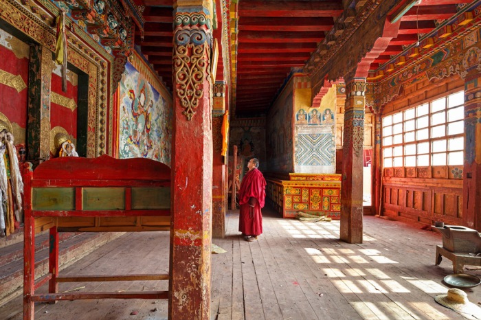 Монах у входа в монастырь Golo Gompa, Сычуань, Китай. Автор фото: Colin Miller.