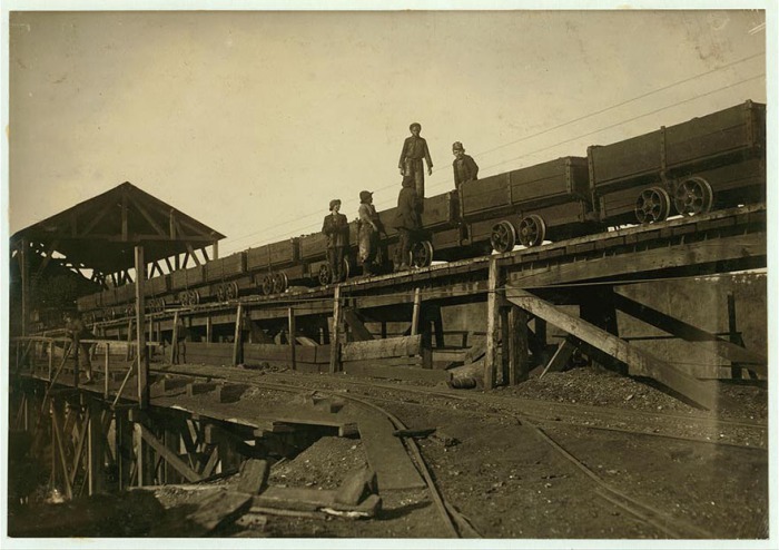 Мальчишки работают на движущихся платформах, которые перевозят уголь. Автор фото: Льюис Хайн (Lewis Hine). 