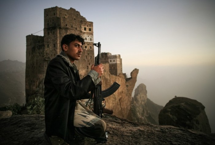 Йемен: Молодой человек охраняет поля в долине.