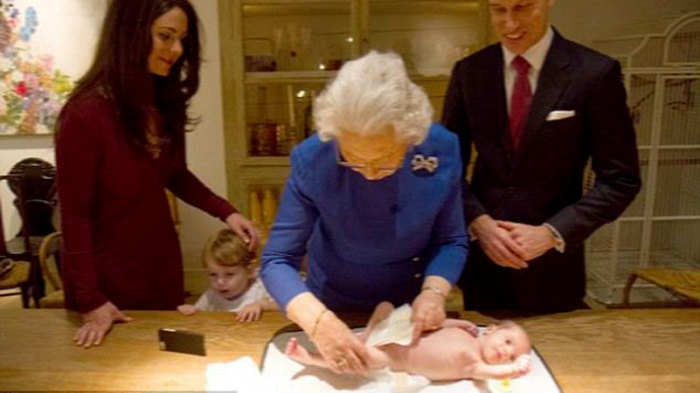 Королева Елизавета II пеленает малышку.