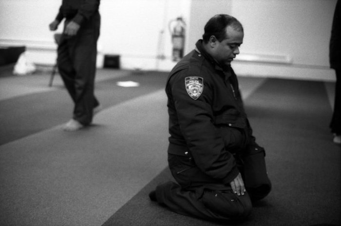 Офицер полиции  во время молитвы. Парк 51,  Манхэттен, Нью-Йорк, 2012 год. Автор: Robert Gerhardt.