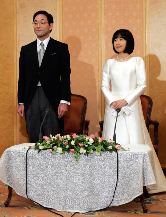 Г-жа Саяко Курода и Йошиеки Курода участвуют в пресс-конференции после их свадебной церемонии в Токио в 2005 году.