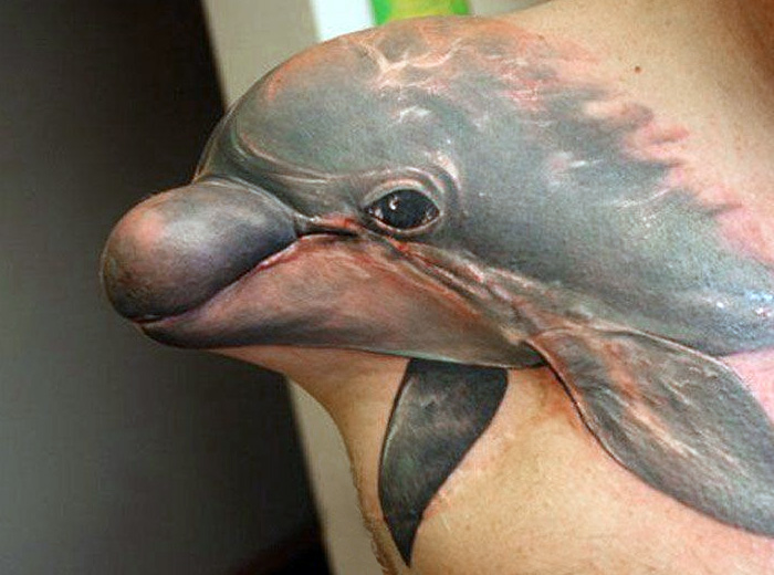 Сильный мужчина с татуировкой прекрасного дельфина