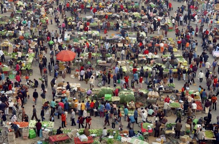 Люди покупают овощи на рынке в Пекине.