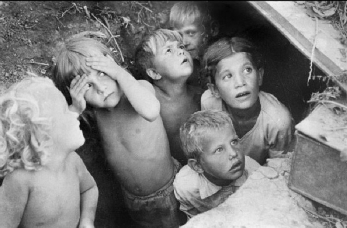 Дети прячутся от бомбёжки и смотрят с надежной в небо.