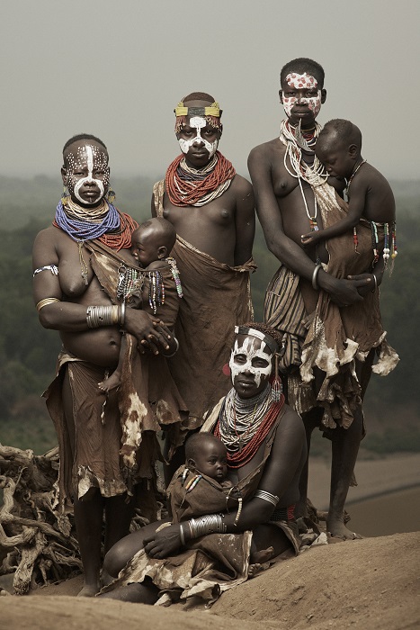 Представители племени каро с раскрашенными лицами, украшены яркими аксессуарами: бусами, украшениями из цветов и насекомых.