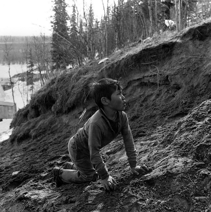 Мальчик играет с хаски стоя на четвереньках, Шунгнак, Аляска, 1973 год.