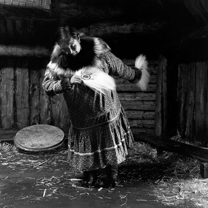 Пожилая женщина танцует танец с перьями и бубном. Тунунак, Аляска, апрель 1976 год.