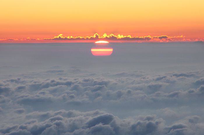 Вид на восходящее солнце, которое словно выплывает из облачного моря, с вершины горы Роччамелоне (3538 метров).