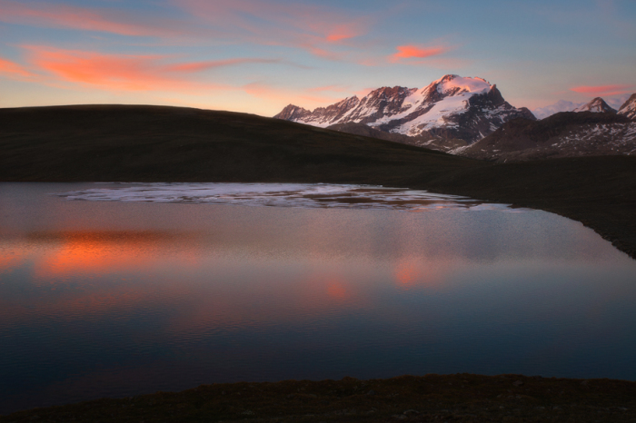 Спокойный и выразительный закат над озером Россет и горными вершинами в Национальном парке Гран Парадизо, Италия.