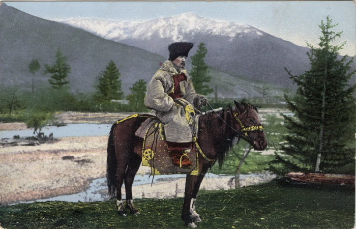 Мужчина восседает на лошади в куараан борук (головной убор) и тон (шуба из овчины).