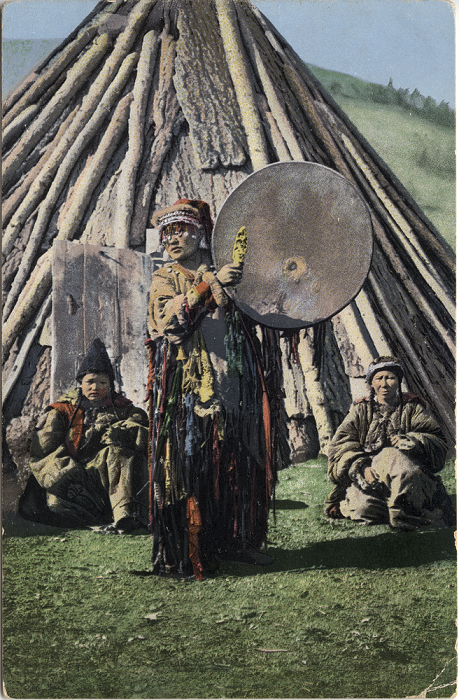 Алтайский шаман играет на бубне возле традиционного жилища - чаадыр.
