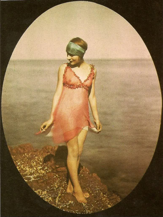 Молодая дама в шелковом костюме на скалистом берегу.