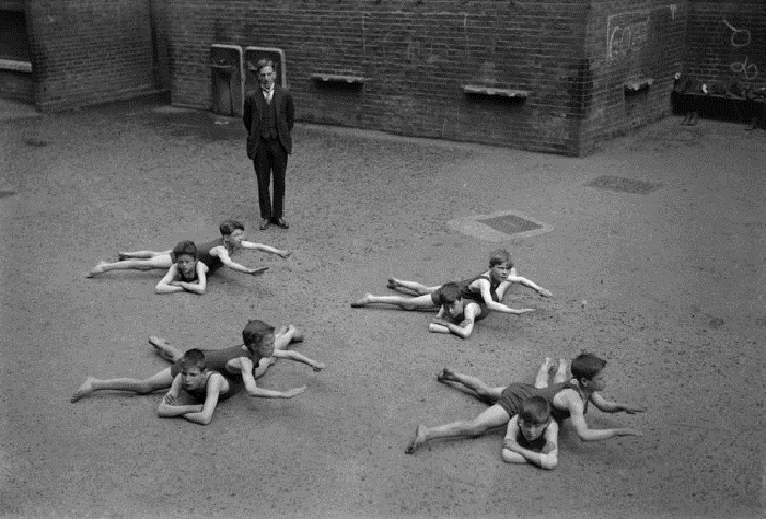 Дети, не имеющие доступа к воде, учатся плавать на школьном дворе. 1920-е годы.