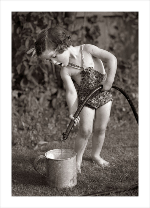 Маленькая девочка точит воду для полива рассады.