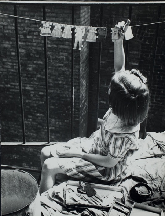 Девочка сушит детскую одежду на веревке, 1935 год.