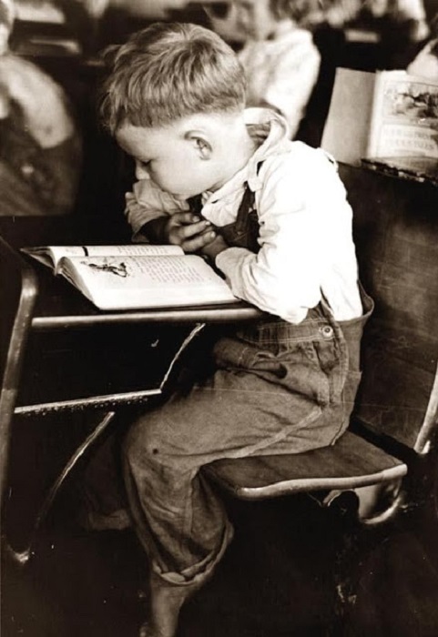 Мальчишка читает в школе за партой, 1938 год.