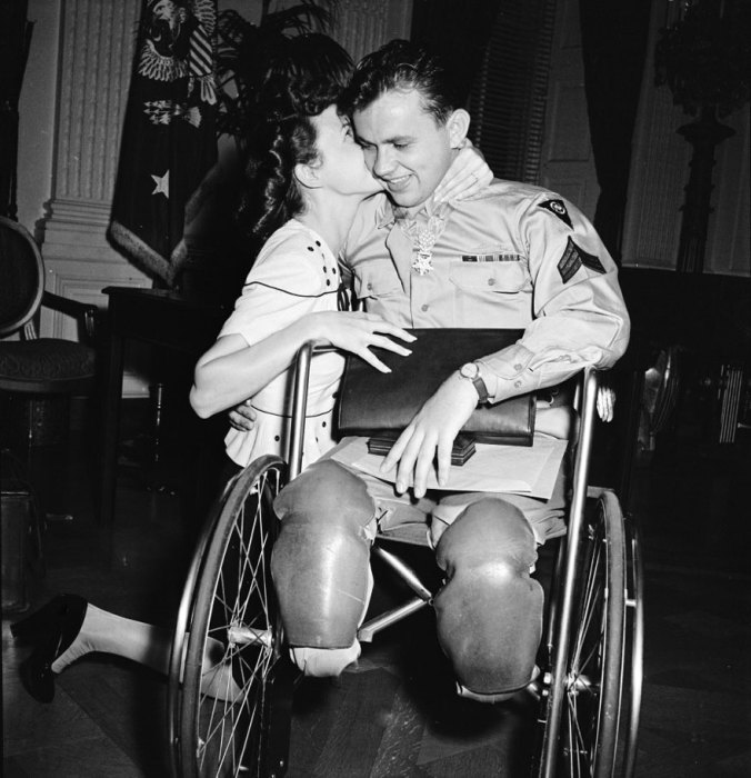 Девушка целует жениха вернувшегося с войны в инвалидной коляске, 1945 год.