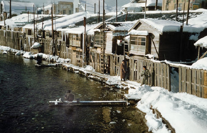 Девушка стирает белье в холодное зимнее утро в Охотском море.