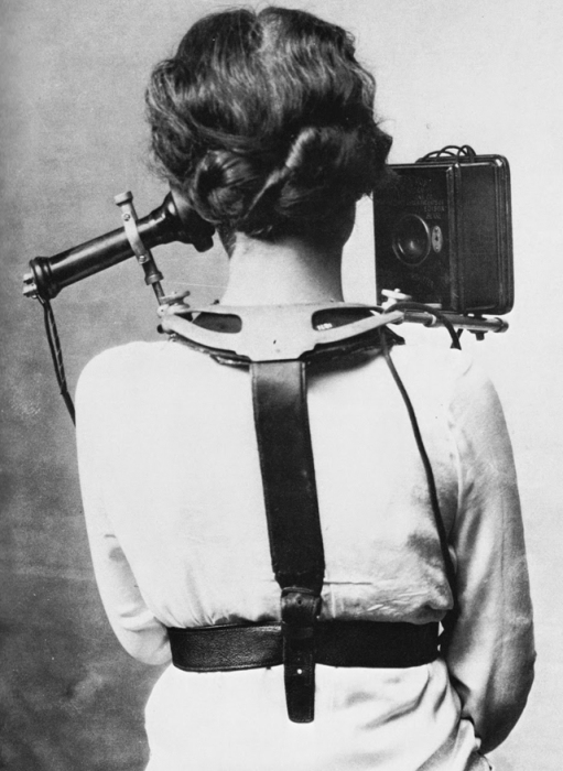Женщина с телефоном, который зафиксирован специальными ремнями на спине.