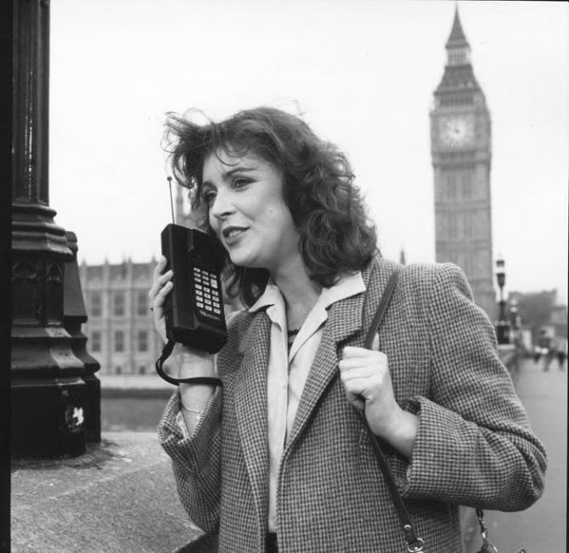 Женщина общается по сотовому телефону.