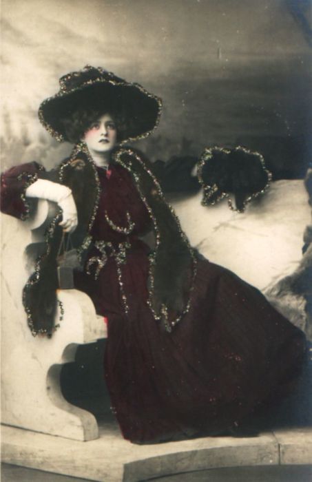 Женщина в насыщенном бордовом платье с тёмными аксессуарами.