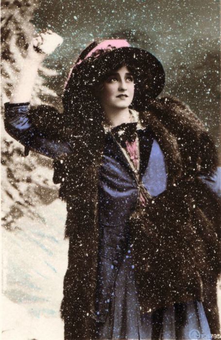 Чудесная танцовщица, певица и актриса в превосходном синем наряде радуется снегу.
