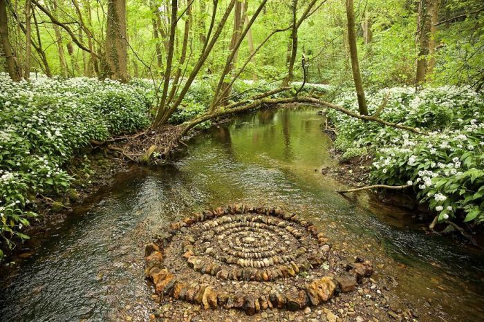 Спираль, тщательно выложенная из мокрых камней посредине лесной реки.