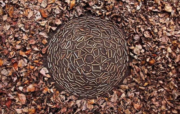 Объемный арт-объект, созданный из палочек на расчищенной от опавших листьев земле.