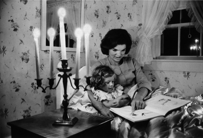 Джеки Кеннеди читает книгу дочери Кэролайн в летнем загородном доме.