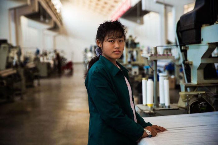 Девушка за работой на текстильной фабрике в Пхеньяне.