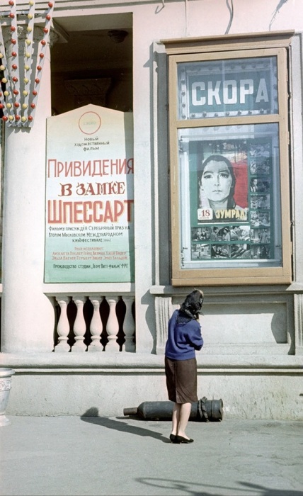 Женщина изучает афиши на здании кинотеатра «Победа».