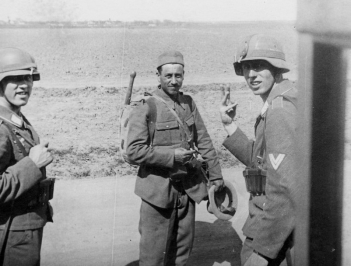 Два солдата немецкой дивизии «Германн Геринг» общаются с румынским солдатом.