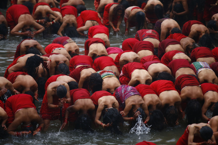 Непальские верующие женщины купаются в Святой купальне после чтения молитв в храме Пашупатхинат во время проведения праздника Швашани Брата Катха, посвященного богине Шри Швашани в Катманду. Автор фотографии: Сканда Гаутам (Skanda Gautam).