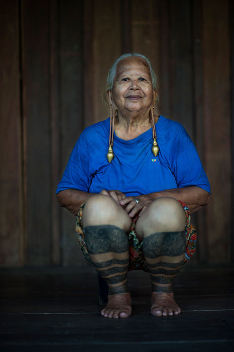 Пожилая женщина с татуировками на ногах.