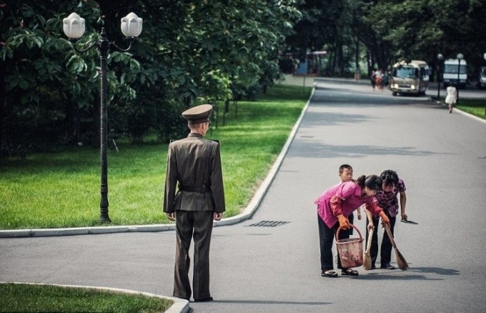 Уборщицы наводят порядок в парке Пхеньяна под бдительным контролем.