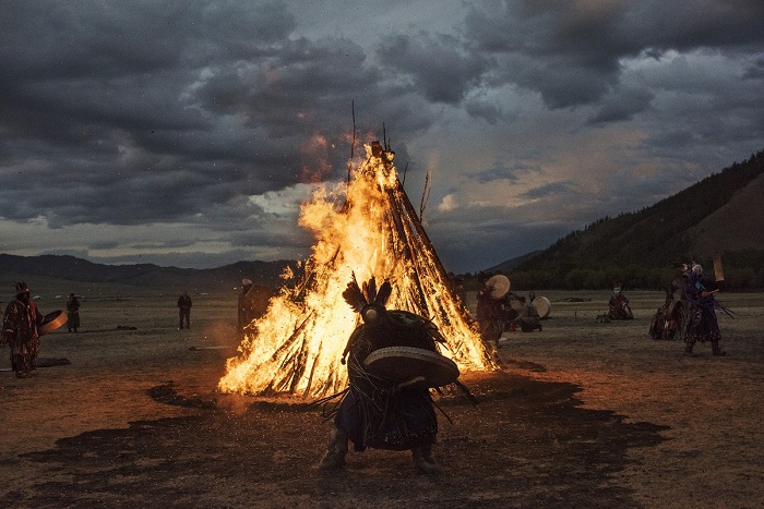 Ритуальный обрядовый танец шамана с бубном у огромного костра.
