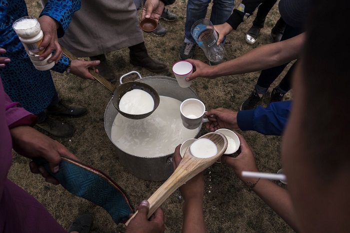 Шаманы разливают молоко, чтобы преподнести его в качестве подношения почитаемым духам.