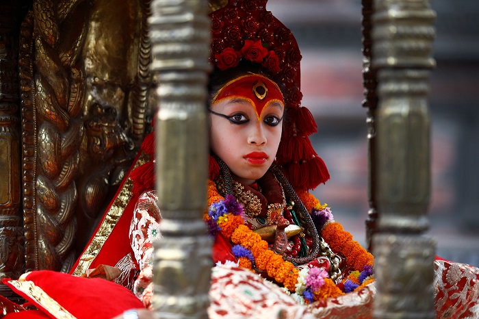 Богиня Кумари с огненным глазом на лбу одета в красные одежды.